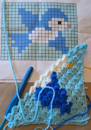 Crochet in progress of a pixelated bird